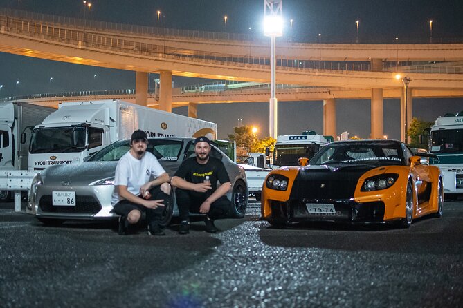 Veilside Mazda RX-7 und Toyota 86 mit ihren Fahrern bei einem nächtlichen Treffen an der Daikoku PA